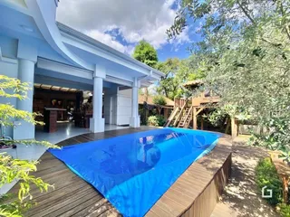 Vista da piscina e deck de madeira em uma propriedade.