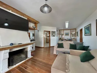 Sala de estar com lareira e piso de madeira em imóvel no Brasil.