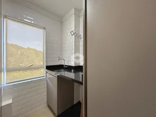 Banheiro com revestimento de azulejo branco e janela.