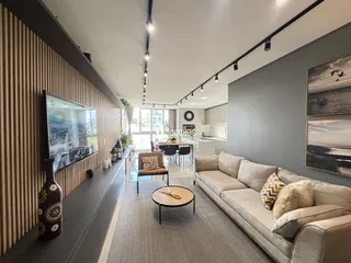 Sala de estar moderna com sofá e televisão em um apartamento.
