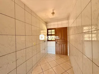 Foto de um corredor interno com paredes revestidas em azulejos claros.