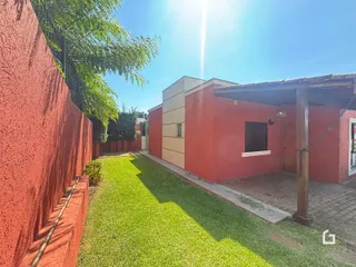 Vista externa de uma propriedade com muro alto e gramado verde.