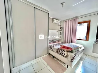 Quarto com cama e armários em um ambiente claro.