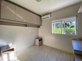 Um quarto com armários superiores e uma janela que oferece vista para a vegetação externa.
