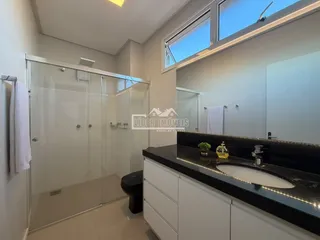 Foto de um banheiro moderno com box de vidro e bancada escura.