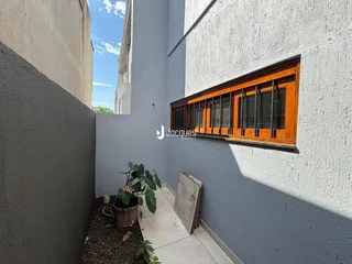 A fachada de uma residência em Lajeado, Brasil, mostra uma janela com moldura de madeira.