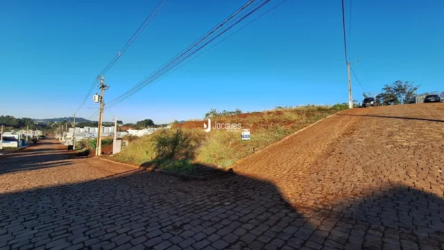 Vista externa da propriedade com calçamento de tijolos e declive.