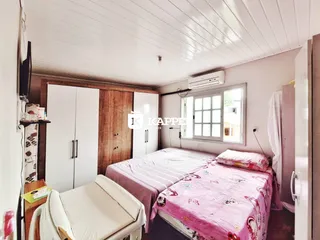 Quarto com duas camas e armários de madeira em um imóvel.