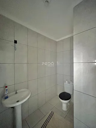Foto de um banheiro com piso cerâmico e paredes brancas.