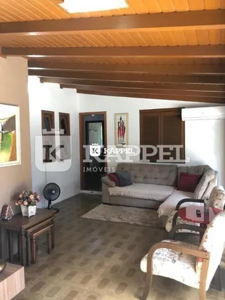 Sala de estar com sofá e piso de madeira em um imóvel.