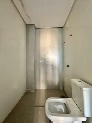 Vista de um corredor com um vaso sanitário em um imóvel.