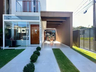 Fachada moderna de uma residência em Lajeado, Brasil, com entrada de vidro e jardim.