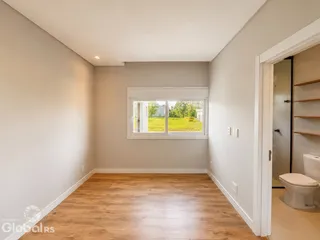Sala de estar com piso de madeira e janela para o jardim.