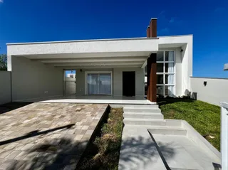 Fachada de uma residência moderna com pátio e jardim.