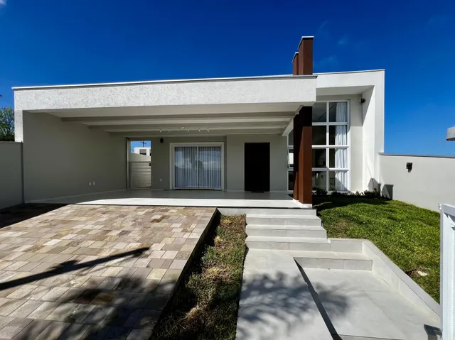 Fachada de uma residência moderna com pátio e jardim.