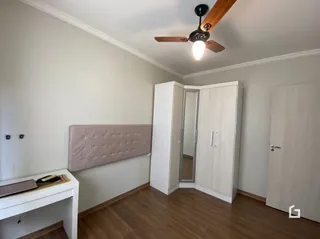 Quarto com cabeceira e armários em um ambiente claro.