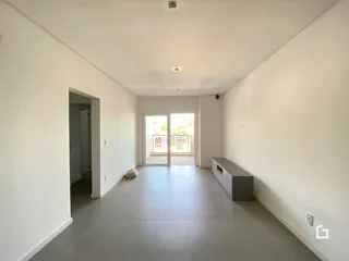 Corredor interno com paredes brancas e piso cinza claro.