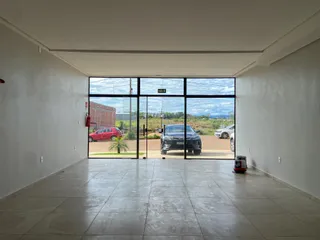 Sala ampla com grandes janelas de vidro que dão vista para a área externa.