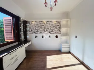 Sala de estar com piso de madeira e janela grande.