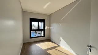 Esta é uma foto de uma sala com piso de madeira clara e uma grande janela.