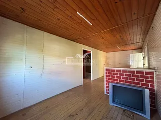 Hall de entrada com piso de madeira e teto de madeira em uma residência.