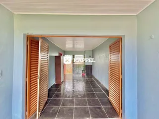 Corredor interno com piso de cerâmica escura e portas de madeira.