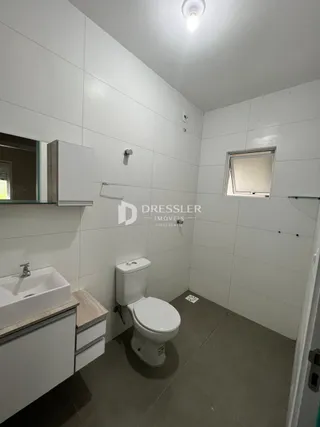Foto de um banheiro moderno com piso de cerâmica e louças sanitárias brancas.