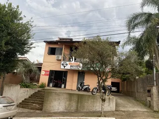 Fachada de uma residência em Lajeado, Brasil, com vegetação ao redor.