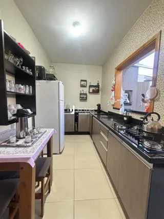 Vista de uma cozinha moderna com armários e bancadas em Lajeado.