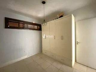 Quarto com armário embutido e piso de cerâmica.