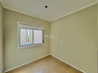 Ambiente interno com piso de madeira clara e paredes bege.