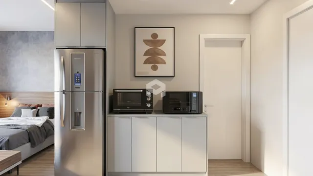 Quarto moderno com cama e geladeira em um apartamento.