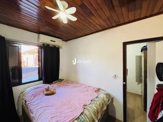 Quarto com teto de madeira e janela na sala.