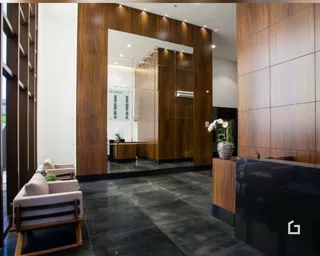 Sala de estar com revestimento de madeira escura e piso escuro.