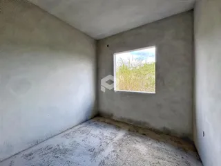 Ambiente interno com paredes brancas e uma janela de luz.