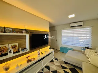 Sala de estar moderna com painel de madeira e televisão montada na parede.