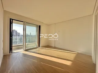 Interior de um cômodo com piso de madeira e portas de vidro.