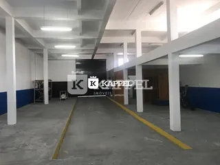 Foto de um espaço interno com estrutura de concreto aparente e teto branco.