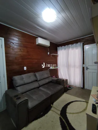 Sala de estar com paredes de madeira e sofá grande.