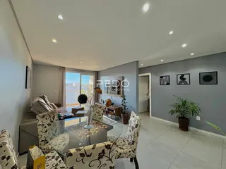 Sala de estar com sofá e mesa de centro em um apartamento.