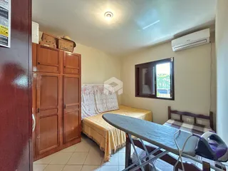 Quarto com armário de madeira e cama em um apartamento.