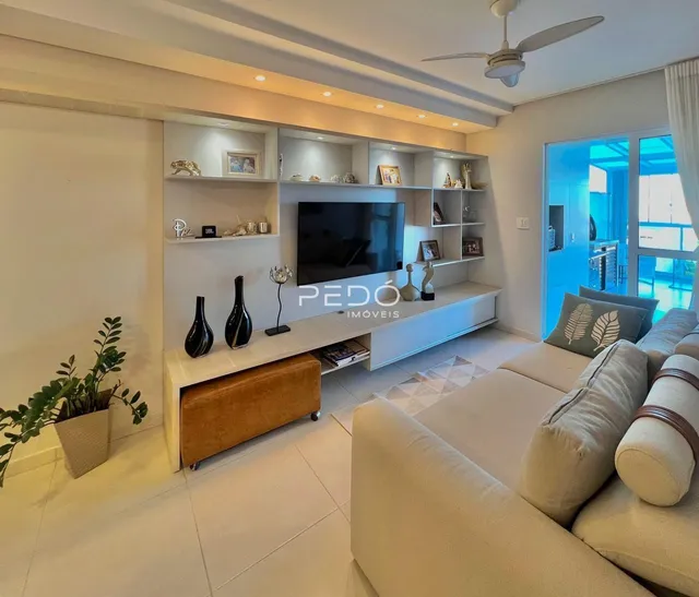 Sala de estar moderna com sofá e painel de TV em um apartamento no Brasil.
