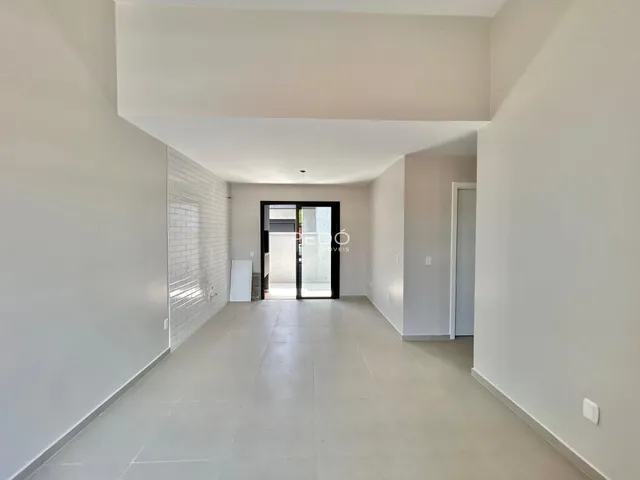 Hall de entrada de uma residência com paredes brancas e piso claro.