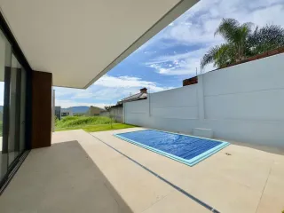 Foto de uma área externa com piscina e deck em uma residência.