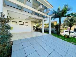 Fachada de uma casa moderna em Lajeado, Brasil, com área externa pavimentada.