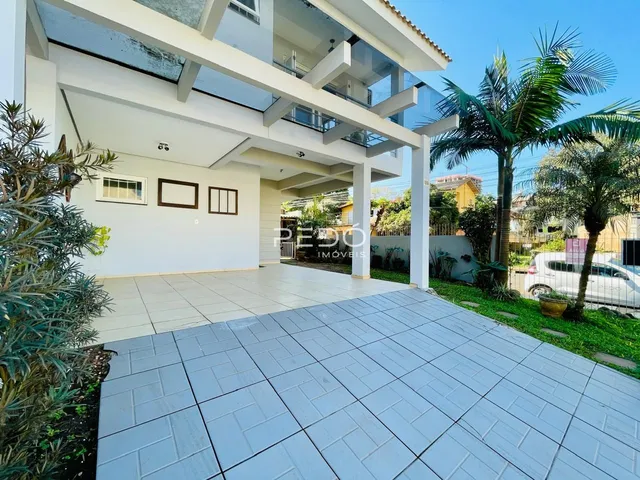 Fachada de uma casa moderna em Lajeado, Brasil, com área externa pavimentada.