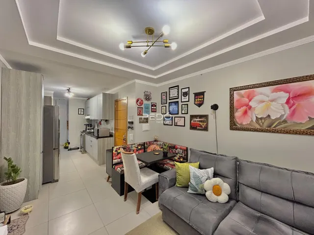 Sala de estar moderna com sofá cinza e decoração de parede em Lajeado.