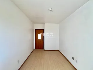 Hall de entrada com piso de madeira clara e porta de madeira.
