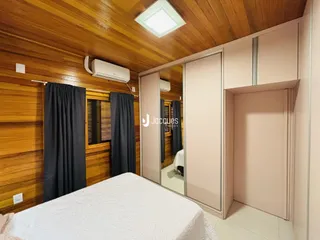Quarto com paredes de madeira e armários embutidos.