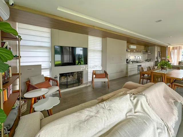Sala de estar com lareira e área de jantar em um imóvel em Lajeado.